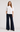 Woman wearing the Castca white floral appliqué top with dark wide-leg pants, front view.