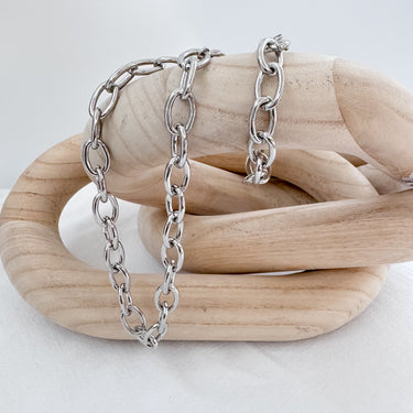 Chunky silver chain necklace by Matte displayed on wooden sculptural stand
