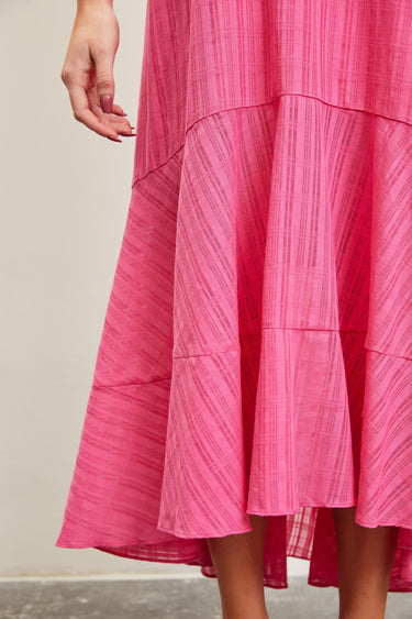 Close up of model wearing Ainsley Pink Midi Dress with ruffled hem and thin straps.