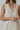 Model wearing natural linen Ezeiza Dress with fringed V-neckline.