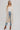 Woman wearing long beige Coavilla Cardigan over white tank top, denim shorts, and brown boots – Matte Clothing