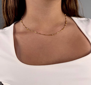 Model wearing Colca gold plated bar and bead chain necklace by Matte, delicate layering style