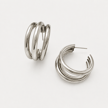 Collete Hoop Earrings featuring polished silver-plated triple-band hoop earrings with a layered stacked-hoop design, rounded high-shine finish, lightweight construction, secure hinged closure, and a bold yet timeless silhouette.