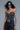 Black corset top with sparkling crystal design, styled with chunky belt and jeans.