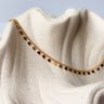 Dalia necklace silver plated heart charm chain on textured beige background