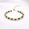 Darcity Beaded Bracelet gold bead bracelet with green stone accents adjustable cord style on neutral background showing polished beads and delicate spacing.