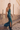 Model wearing teal sequin Daria Jumpsuit with halter neckline and side slit — Matte Concept Store
