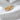Darsy Ring gold eternity band with baguette-cut stones on textured white surface

