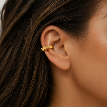 Debbie Ear Cuff worn on ear showing no-piercing fit and bold gold stacked jewelry look.