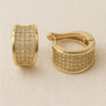 Champagne-gold pavé huggie earrings with micro-crystal detailing on white linen backdrop, Dessidere Huggie Earrings.