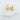 Dol gold plated drop stud earrings by Matte, textured bar design displayed on wood and leather stand