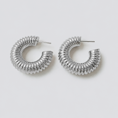 Drake Hoop Earrings featuring polished silver-plated ribbed hoop earrings with a bold sculptural silhouette, evenly spaced textured ridges, chunky rounded profile, secure post-back closure, mirror-like finish, and a modern statement design