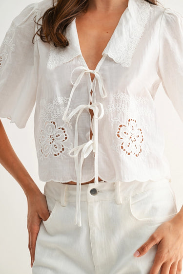 White blouse with lace details and a woman wearing it against a white background