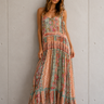 Woman wearing the Eloisa floral maxi dress featuring a tiered silhouette, adjustable tie straps, and a flowing lightweight fabric.