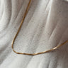 Encanto gold plated chain necklace by Matte, delicate flat chain on neutral fabric