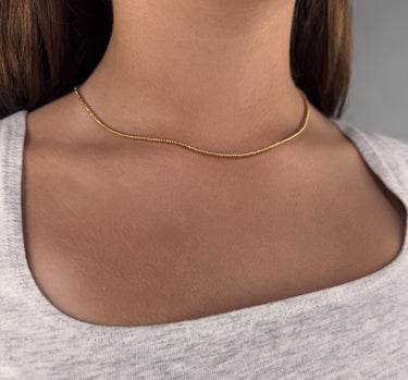 Model wearing Eris Necklace by Matte, gold filled beaded chain necklace with minimalist design