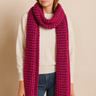 Woman wearing the Eto Pashmina in fuchsia chunky knit wool, vibrant texture, cozy editorial photo – Matte.
