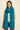 Woman wearing the Eto Pashmina in teal wool knit with airy texture, soft natural light, Matte.
