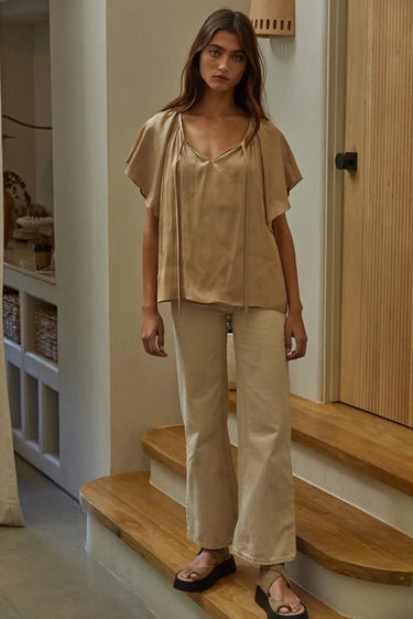 Etta Blouse styled with relaxed pants showing airy flutter sleeves and effortless movement.
