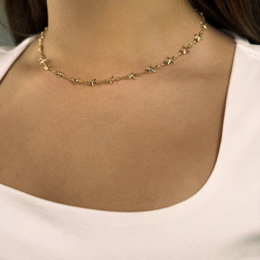 Model wearing Evadne gold plated necklace with multicolor star charms
