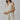 Model wearing natural linen Ezeiza Dress with fringed V-neckline.