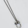 A gold-plated necklace with a small horse charm on a white background.