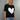 Woman wearing a black t-shirt with a white heart design on a gray background
