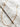 Follow gold plated beaded chain necklace by Matte, displayed on marble background