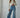 Full-length view of woman in ivory lace long sleeve top paired with high-waisted wide-leg jeans, Heartland Lace Top by Matte.

