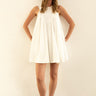Model wearing Nara Mini Dress in white with halter neckline and relaxed fit.