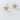 Gaia gold plated stud earrings by Matte, modern paperclip design with crystal accents on neutral stone background