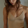 A female model wearing a beige shoulder strap top and a leopard print skirt.