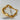 Gold bracelet with irregular organic-shaped beads and small round spacers displayed on white stone background
