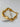 Gold bracelet with irregular organic-shaped beads and small round spacers displayed on white stone background