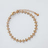 Gold plated Caeli bracelet with delicate cross-link design on white background