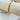Gold beaded bracelet with minimalist geometric tube beads displayed on wood stand - Matte Jewelry
