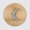 Hex Hair Clip shaped like a crescent moon with crystals on wood background, celestial accessory photo for Matte.