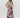 A model wearing floral print Hibiscus Pants with an elastic waistband and side pockets, paired with a beige spaghetti strap top.