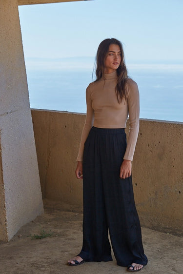 Ikara Top full-length view styled with wide-leg black trousers and fitted silhouette.