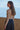 Ikara Top side profile highlighting ribbed fabric and mock turtleneck neckline.