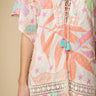 A multicolored floral lace-up cover-up dress with star accents and intricate lace details, displayed on a person.
