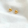 Joelle stud earrings by Matte, gold plated round ball studs on white fabric