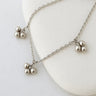 Silver anklet with three-ball pendants on a white background