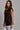 Kaia Vest side profile of black tailored vest styled with white pants.