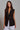 Kaia Vest black longline tailored vest styled with white trousers.