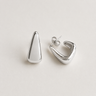 Kira Hoop Earrings featuring polished silver sculptural hoop earrings with a teardrop silhouette, smooth mirror finish, lightweight hollow design, secure post-back closure, and modern statement style, displayed on a soft white background.