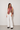 Kirby Top colorful floral scarf-style top with fringe trim styled with white wide-leg pants front view.