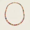 Kiron Necklace rainbow tennis necklace with multicolored cubic zirconia stones and gold-plated setting on neutral background.