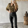 Model wearing Kuta Skinny black foil stretch pants with high waist and ankle fit.