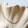 Landing gold plated chain necklace by Matte, flat minimalist chain on neutral fabric